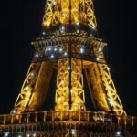 the eiffel tower is lit up at night