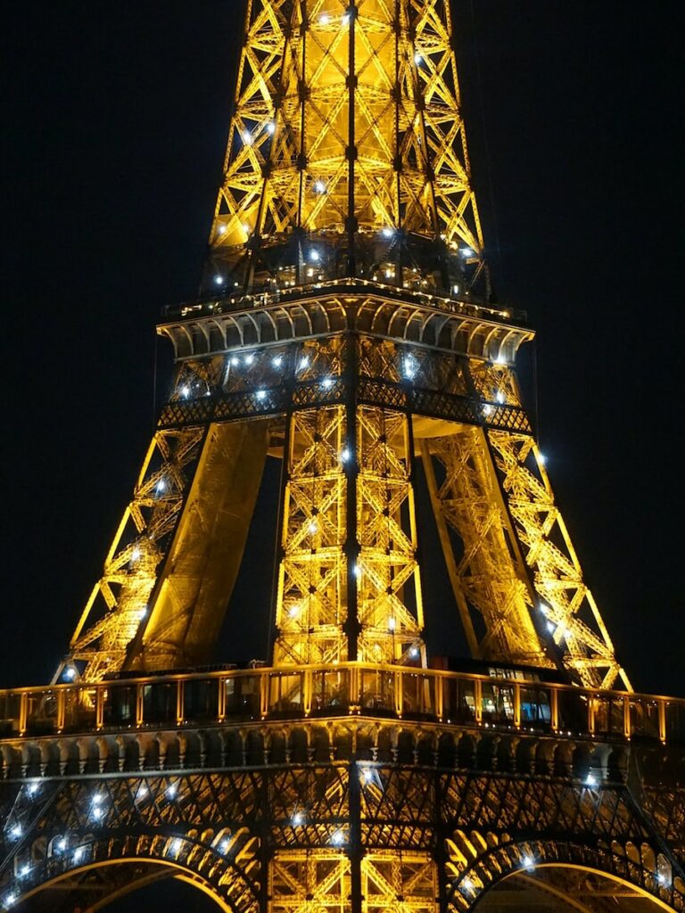 the eiffel tower is lit up at night